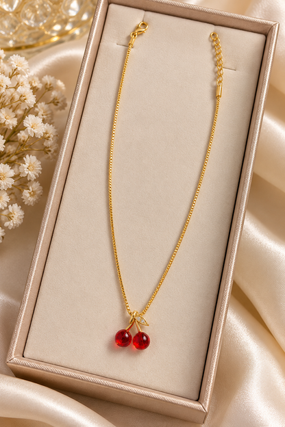 Collar de cereza de la marca Nia-Vanity con diseño delicado y detalles en forma de cereza, en tonos rojos y plateados.